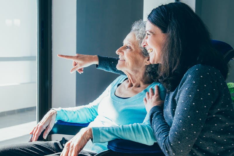 Joyful woman taking care of elderly mother