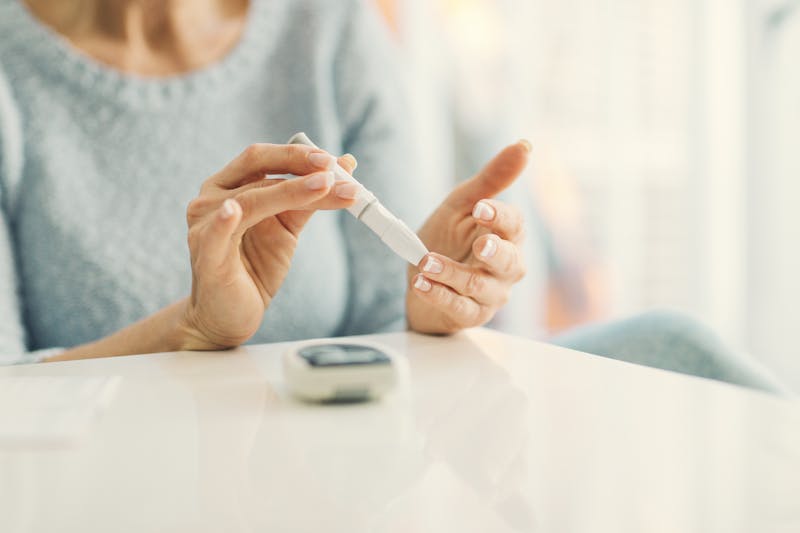 Mature Woman Doing Blood Sugar Test at home.