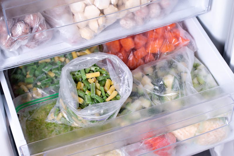 Bags with frozen vegetables in refrigerator. Frozen Asparagus Beans