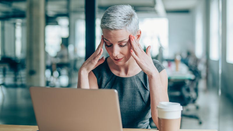 Female entrepreneur with headache sitting at desk