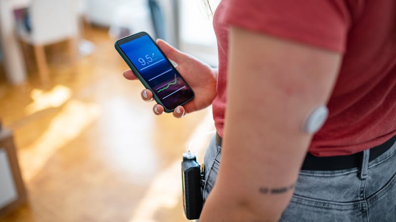 Woman with Type 1 Diabetes Checking Blood Data on Phone App