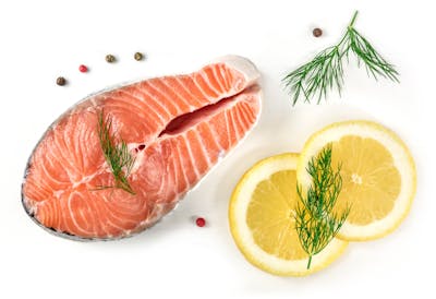 Salmon steak with lemons, dill, and peppercorns, on white