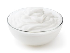 Sour cream in glass bowl isolated on white background with clipping path