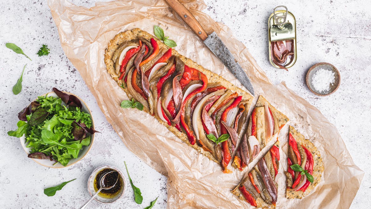 Mediterranean high protein pizza with roasted vegetables and anchovies