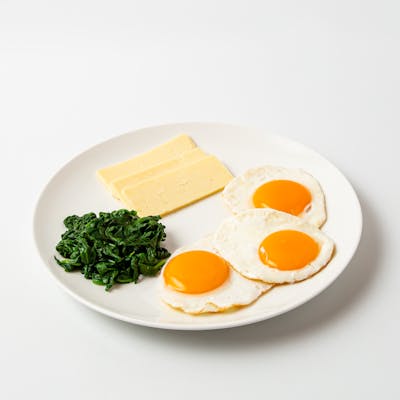 female vegetarian breakfast with cheese eggs and spinach