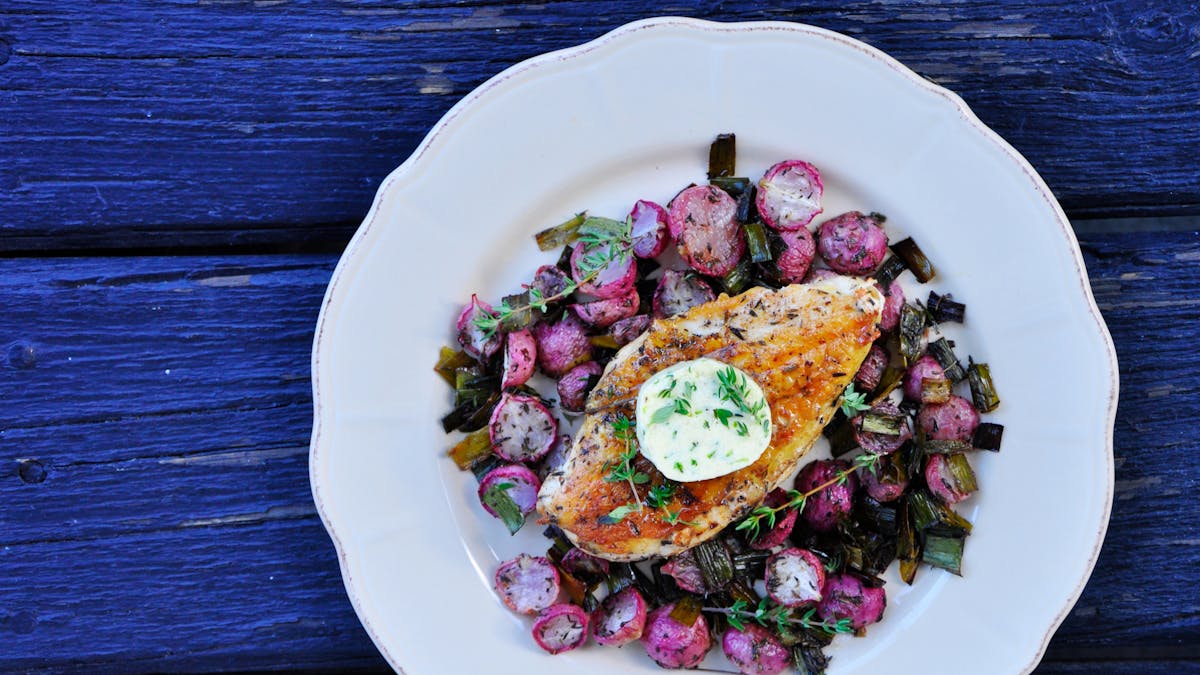 Oven-baked chicken breast and radishes with thyme butter