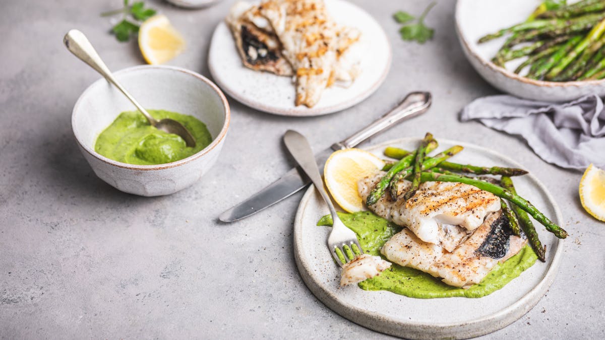 Hake fish in green sauce with asparagus