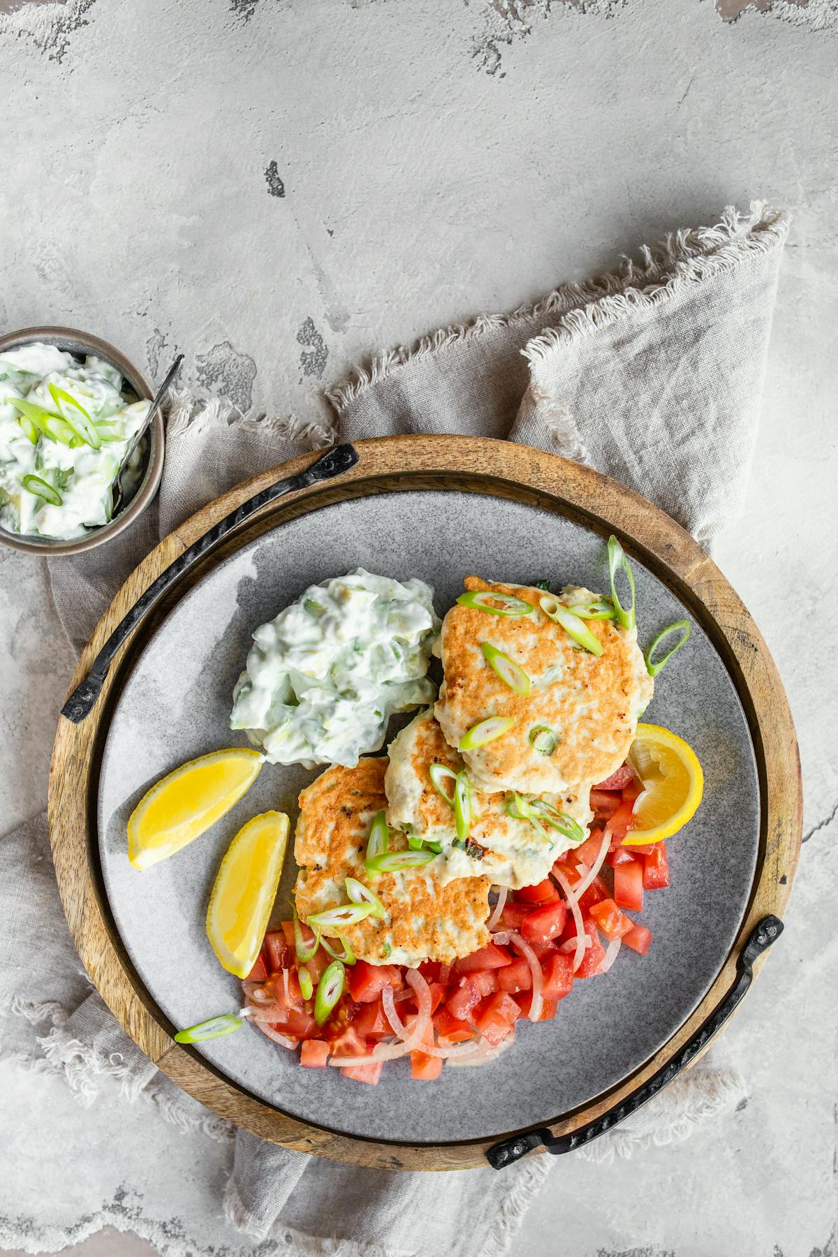 Keto chicken fritters with avocado tzatziki and tomato salad