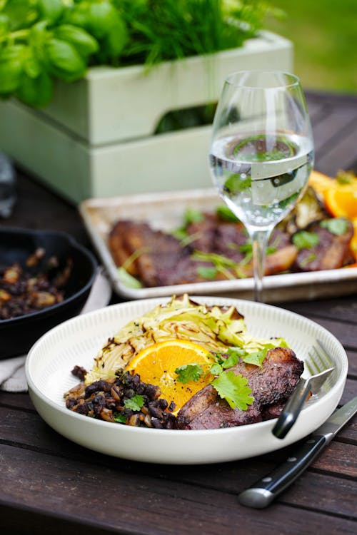 Grilled picanha with black beans, cabbage and orange