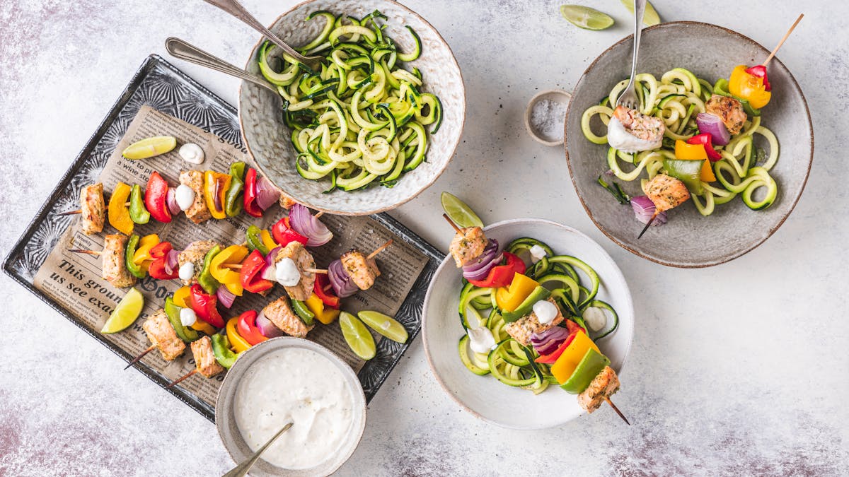 Rainbow cajun salmon skewers with zoodles & garlic lime sauce